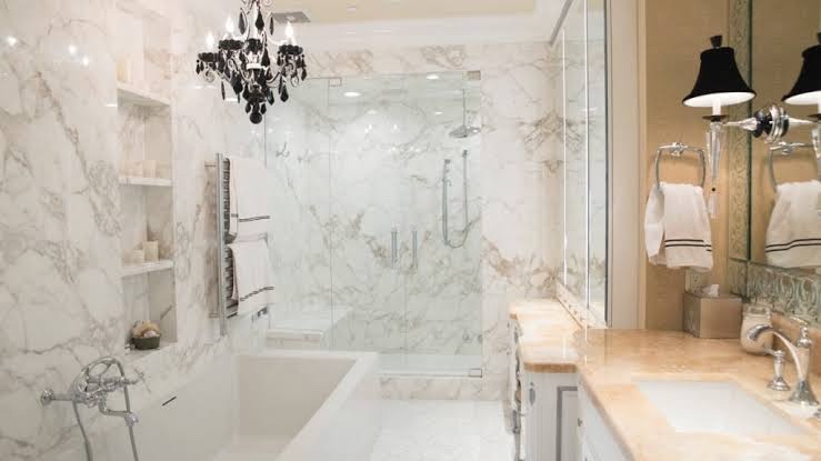 Marble bathroom with a frameless glass shower and a large mirror